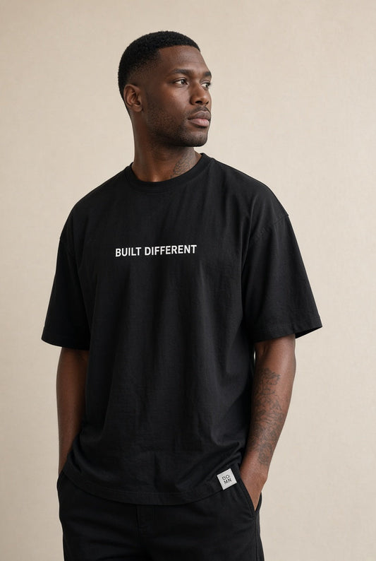 Model wearing the DOMN Built Different oversized heavyweight T-shirt in Obsidian Black, front view